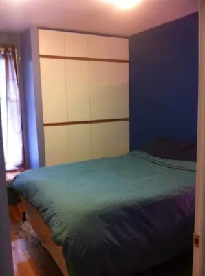 a bedroom with a bed and a blue wall at Lovely home in Leslieville in Toronto