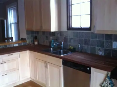 a kitchen with white cabinets and a sink and a window at Lovely home in Leslieville in Toronto