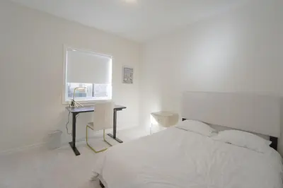 a bedroom with a bed and a desk and a window at New Custom-built House Close to Rogers Stadium in Toronto