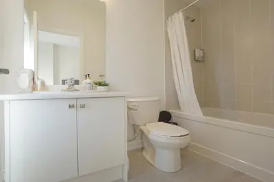 a white bathroom with a toilet and a tub and a sink at New Custom-built House Close to Rogers Stadium in Toronto