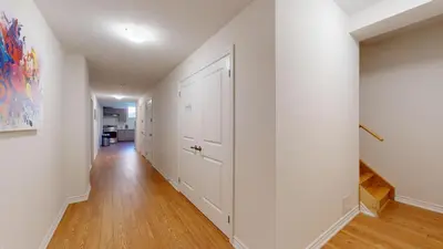 an empty hallway with white walls and wood floors at New Custom-built House Close to Rogers Stadium in Toronto