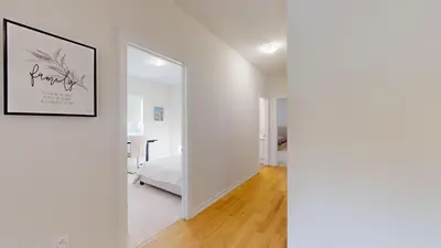 a white room with a bed and a mirror at New Custom-built House Close to Rogers Stadium in Toronto
