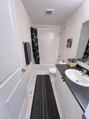 a white bathroom with a sink and a toilet at Brand New Luxurious 4B Townhouse in Oshawa