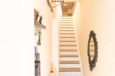 a staircase in a house with a mirror and shoes at Room in cozy house close to Lawrence Ave, WiFi, parking in Toronto