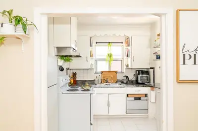 a white kitchen with white cabinets and a sink at Room in cozy house close to Lawrence Ave, WiFi, parking in Toronto