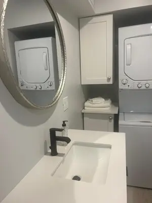 a white bathroom with a sink and a mirror at Treetop Suite in Haliburton