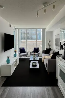 a living room with a couch and a tv at Upscale 1 Bed & Den Downtown Toronto in Toronto