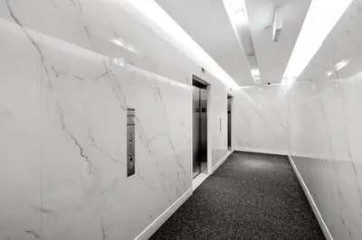 a hallway with white marble walls and a door at Upscale 1 Bed & Den Downtown Toronto in Toronto