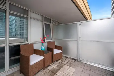 a balcony with two chairs and a vase with a flower at Upscale 1 Bed & Den Downtown Toronto in Toronto