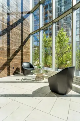 a lobby with two chairs in a building with windows at Upscale 1 Bed & Den Downtown Toronto in Toronto