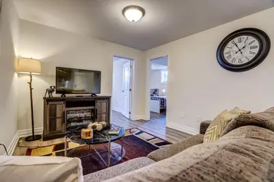 a living room with a couch and a clock on the wall at GLOBALSTAY New Basement 4 Bd in Port Elgin in Port Elgin