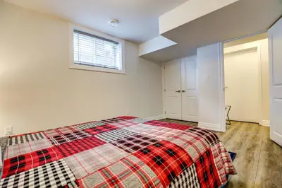 a bedroom with a bed with a plaid blanket at GLOBALSTAY New Basement 4 Bd in Port Elgin in Port Elgin