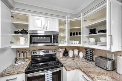 a kitchen with white cabinets and a stove at Modern 5BR Home with Office and Parking and WiFi in Oakville