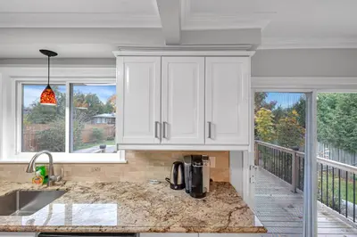 a kitchen with white cabinets and a balcony at Modern 5BR Home with Office and Parking and WiFi in Oakville