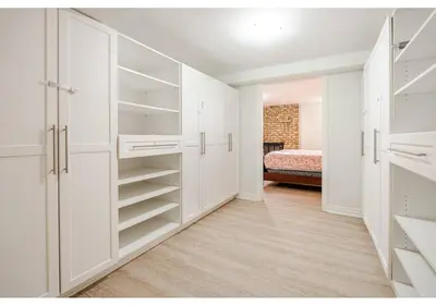 an empty room with white cabinets and a bedroom at 2 bedroom apartment-2 free parking -14 min to Pearson airport in Mississauga