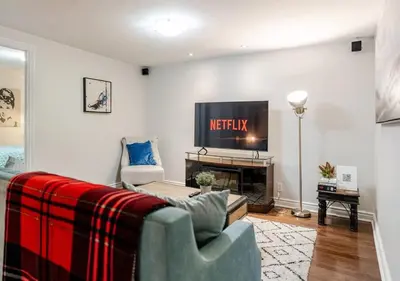 a living room with a couch and a tv at 2 bedroom apartment-2 free parking -14 min to Pearson airport in Mississauga