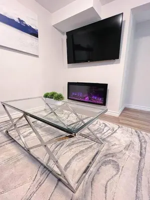 a glass table in a room with a tv on a wall at Charming 1-bed basement, Wi-Fi in Barrie