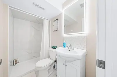a white bathroom with a toilet and a sink at Charming 1-bed basement, Wi-Fi in Barrie