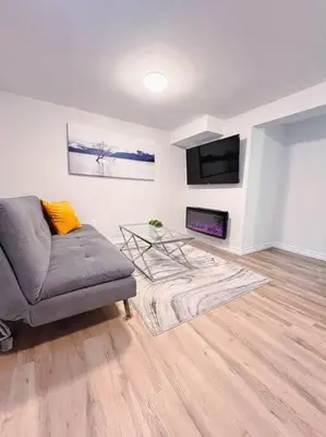 a living room with a couch and a tv at Charming 1-bed basement, Wi-Fi in Barrie