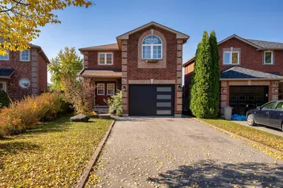 a brick house with a garage and a driveway at Charming 1-bed basement, Wi-Fi in Barrie