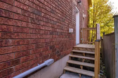 a brick wall with a staircase next to a building at Charming 1-bed basement, Wi-Fi in Barrie