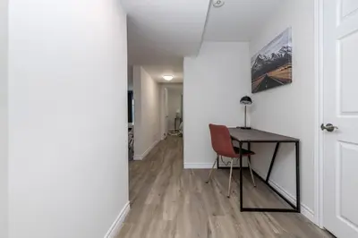 a room with a desk and a table with a chair at Modern & Cozy 1 Bedroom with fast Wi-Fi, BBQ & Patio in Barrie