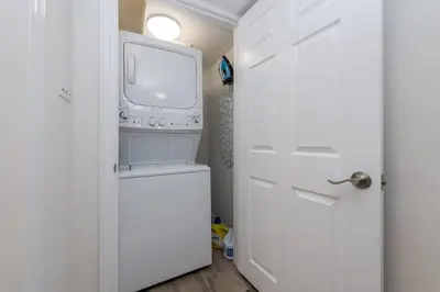 a small white kitchen with a washer and dryer at Modern & Cozy 1 Bedroom with fast Wi-Fi, BBQ & Patio in Barrie