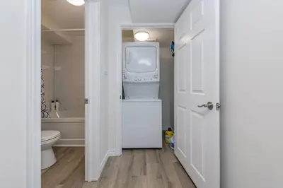 a white bathroom with a washer and dryer in it at Modern & Cozy 1 Bedroom with fast Wi-Fi, BBQ & Patio in Barrie