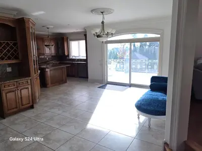 a kitchen with a blue chair and a sliding glass door at Chez Mason in Richmond Hill