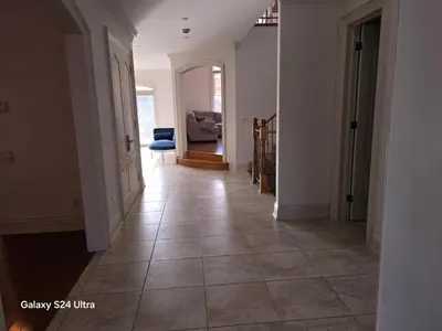 a hallway with a tile floor in a house at Chez Mason in Richmond Hill