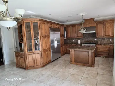 a kitchen with wooden cabinets and a stainless steel refrigerator at Chez Mason in Richmond Hill