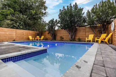 a swimming pool with yellow chairs in a backyard at Modern Master Suite Private Ensuite 29 Nights in Toronto