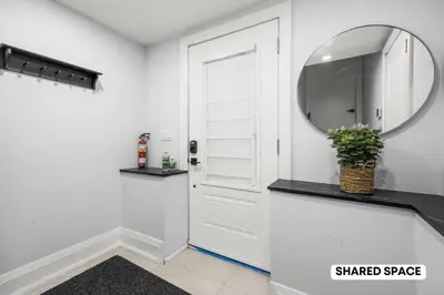 a hallway with a mirror and a white door at Modern Master Suite Private Ensuite 29 Nights in Toronto