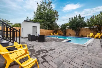 a patio with yellow chairs and a swimming pool at Modern Master Suite Private Ensuite 29 Nights in Toronto