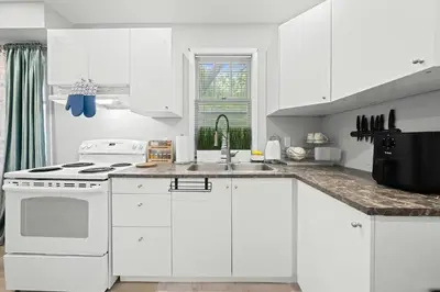a white kitchen with white cabinets and a sink at Private Cozy Room with Free Parking in Toronto