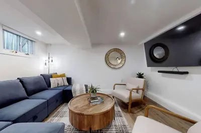 a living room with a blue couch and a table at Fresh and Modern Guest Suite in Toronto
