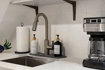 a kitchen counter with a sink with bottles of wine at Fresh and Modern Guest Suite in Toronto
