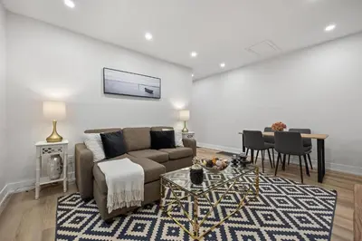 a living room with a couch and a table at Private House with parking & steps to subway in Toronto