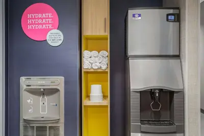 a kitchen with a refrigerator and a coffee machine at Tru By Hilton Bracebridge, On in Bracebridge