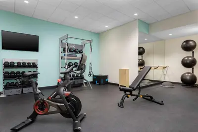 a gym with exercise equipment and a flat screen tv at Tru By Hilton Bracebridge, On in Bracebridge