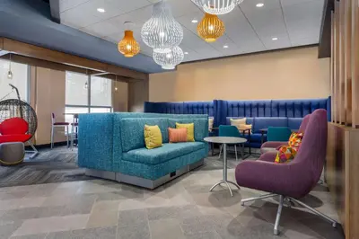 a waiting room with a blue couch and chairs at Tru By Hilton Bracebridge, On in Bracebridge