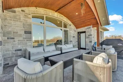 a patio with couches and a stone wall at Private Farmhouse Getaway with hot tub in Waterloo
