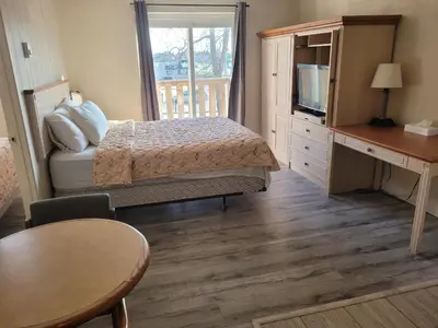 a bedroom with a bed and a desk and a television at Sand Castle Suites Motel in Port Elgin