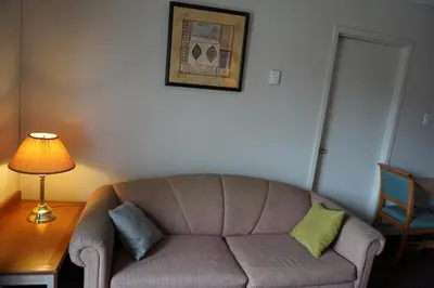 a living room with a couch and a table with a lamp at Sand Castle Suites Motel in Port Elgin