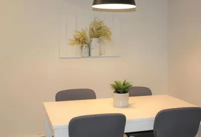 a dining room table with chairs and a potted plant at County Cove - Wellington Suite - Two-Bedroom Wellington Apartment in Wellington
