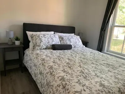a bedroom with a bed with a flowered comforter and a window at County Cove - Wellington Suite - Two-Bedroom Wellington Apartment in Wellington