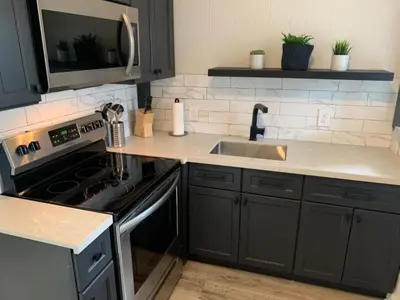 a kitchen with a sink and a stove top oven at County Cove - Picton Suite - downtown Wellington in Wellington