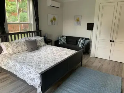 a bedroom with a large bed and a couch at County Cove - Picton Suite - downtown Wellington in Wellington