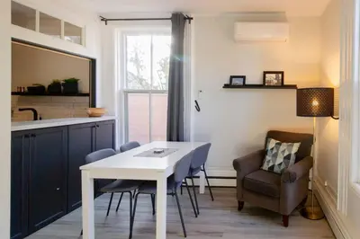 a living room with a table and chairs and a kitchen at County Cove - Picton Suite - downtown Wellington in Wellington