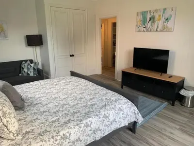 a bedroom with a bed and a flat screen tv at County Cove - Picton Suite - downtown Wellington in Wellington